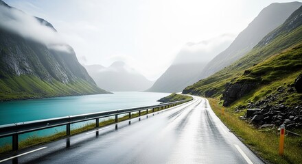 Scenic empty highway along a misty fjord with towering emerald cliffs and reflective turquoise waters in a remote mountainous region