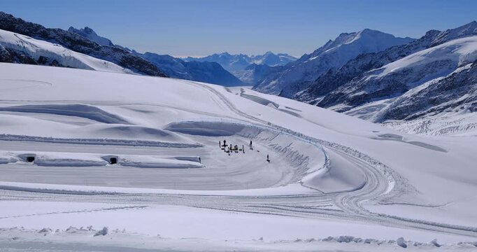 Tourists enjoying snow tubing activities on Aletsch Glacier, Jungfraujoch, Switzerland