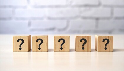 Five wooden blocks with question marks in a row against a white brick wall, evoking inquiry and curiosity.