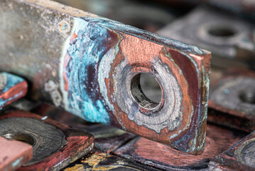 Nonferrous metal plates and patinated copper busbars with visible oxidation show aging and corrosion, symbolizing rare earth elements and price-demand shifts in metallurgical and power markets.