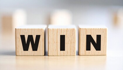 Three wooden blocks on light surface spelling "WIN" in bold black letters with softly blurred background.