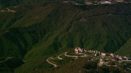 Majestic mountains. View of small mountain towns against the backdrop of mountains covered with green forests that transition into snow-capped peaks. 4k video