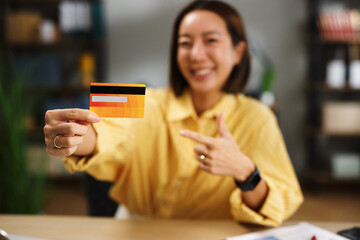 Woman holding credit card pointing to financial convenience