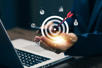 Businessman holding target with arrow hitting center, representing goal achievement, business success, strategic planning, performance optimization, and financial objectives.