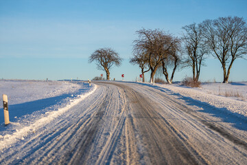 Eine Landstra&szlig;e mit Resten von Schnee im Winter