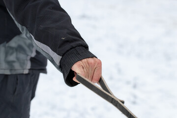 Hand of man walking dog on leash in winter close-up.Man without gloves holding leash with dog.Safe walks with a dog in winter.