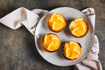 Close up of mini baked tarts with cottage cheese and orange on a plate on the table top view