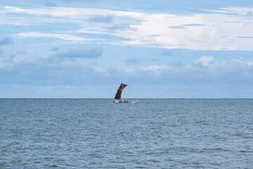Fototapeta premium A traditional fishing boat in the ocean catches fish near Negombo, Sri Lanka.
