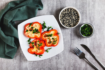 Fried red bell pepper rings with omelette and herbs on a plate on the table top view