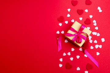 Beautiful and romantic valentines background with present and hearts in red for valentines day or anniversary holiday celebration with copy space