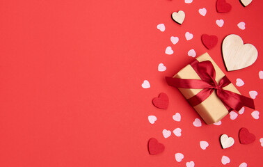 Beautiful and romantic valentines background with present and hearts in red for valentines day or anniversary holiday celebration with copy space