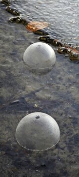 Zwei gefrorene Seifenblasen auf Eis