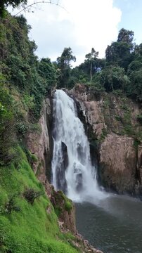 Haew Narok waterfall 60 metres high cascading down rocky cliff in Khao Yai National Park Thailand misty spray lush greenery surrounding