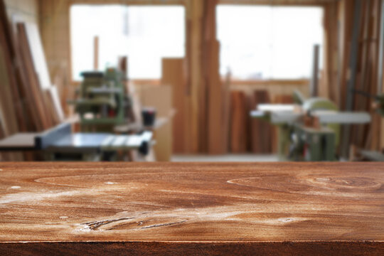 Workshop is filled with various tools and equipment and wooden table on foreground
