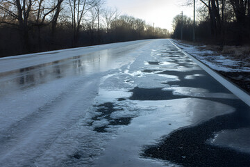 Icy rural road creating dangerous winter driving conditions