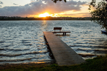 Sunset pier with bench at Jezioro Kłodno lake in Kashubia region, Poland