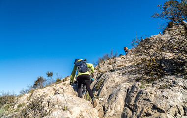 Hikers climbing rocks on a mountain. 