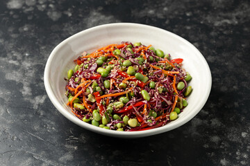 Healthy Edamame Salad with carrots, bell peppers, red cabbage, green onion and sesame seeds.
