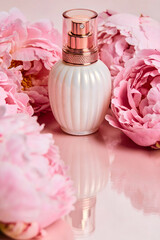 Luxury Perfume Bottle Surrounded by Pink Peonies on Soft Blush Background