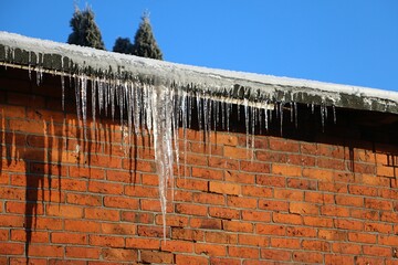 Close-up of large icicles hanging from the gutter on the roof
