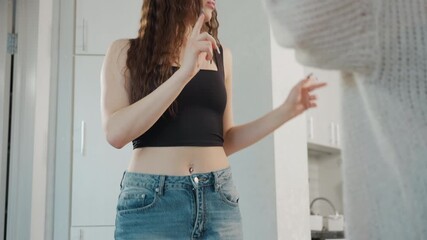 Young White Woman In Kitchen Styling And Arguing With Friend, Tense Hair Check, Curly Locks Examined By Companion, Expressive Gestures, Intimate Domestic Scene With Modern Cabinets And Natural Light