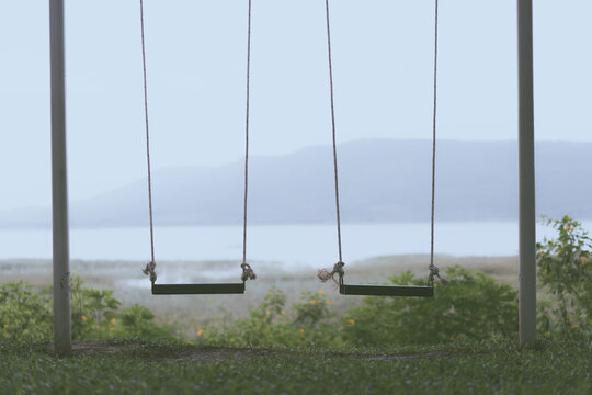 Children swing in the park on rainny day