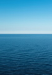 Obraz premium A tranquil view of the vast ocean stretching towards the distant, perfectly straight horizon line under a clear blue sky ,sea ,natural ,infinite