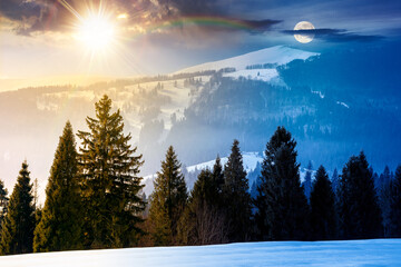 winter solstice landscape. day and night time change concept. fir trees on snow covered hill with sun and moon. place in mountains. winter wonderland background for harmony and progress calendar