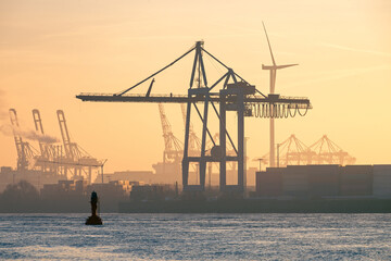 Sunrise over cranes in the harbor at the Elbe River in Hamburg