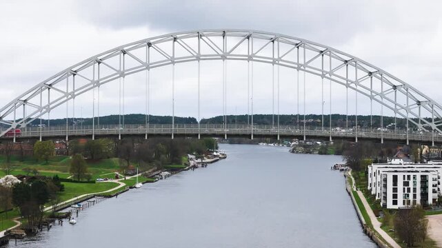 mid centers white steel arch bridge glomma river red vehicle green banks neighborhoods appear fredrikstad norway range drone view aerial urban infrastructure roadway 