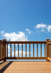 Obraz premium A wooden deck railing frames a beautiful blue sky with soft white clouds, suggesting relaxation and outdoor leisure space for home enjoyment, blue, wooden, garden