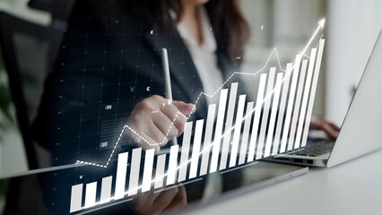 A focused businesswoman analyzes data trends on her laptop, utilizing a graph overlay to visualize growth in a modern office environment. Copula