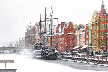 Beautiful ancient sail ship moored on the embankment of frozen Motlawa river in Gdansk