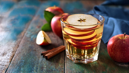 Refreshing Apple Drink With Sliced Apples In A Glass On A Rustic Background