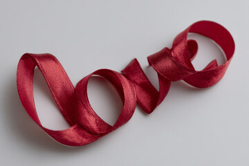 Red ribbon shaped into the word love.