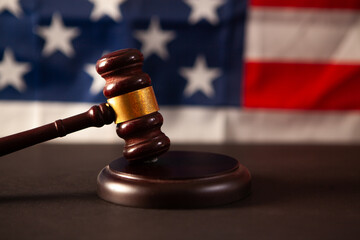 Law theme, mallet of judge, wooden gavel on USA flag background