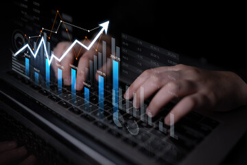 Image showcasing hands typing on a laptop with digital financial graphs illustrating growth trends, representing analysis and data processing in a modern business setting. Scalp