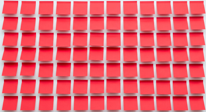 Background of many blank red sticky notes arranged in a neat grid pattern. Office wall texture for brainstorming, agile planning, business reminders, and organization concept.