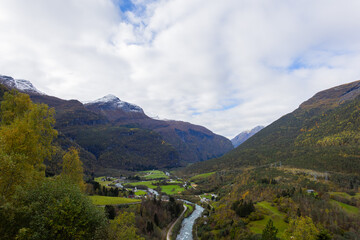 Naklejka premium Autumn landscape in southern Norway with grazing sheep, a cow, and colorful foliage in the surrounding hills.