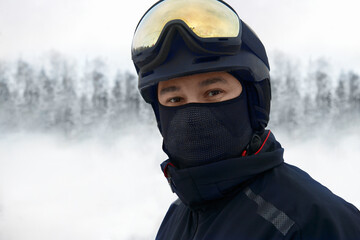 Portrait of a man in ski gear against a blurred background of a ski slope.