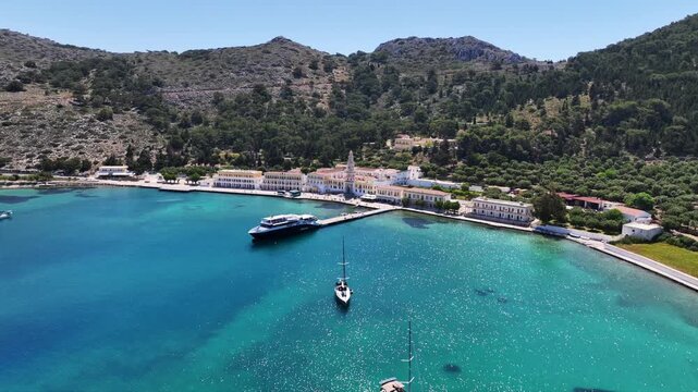 Aerial drone cinematic video of iconic bay and Monastery of Archangel Michael Panormitis, Symi island, Dodecanese, Greece