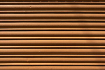 Brown metal roller shutter with horizontal lines