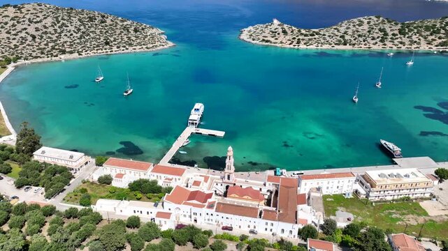 Aerial drone cinematic video of iconic bay and Monastery of Archangel Michael Panormitis, Symi island, Dodecanese, Greece