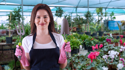 young woman florist in greenhouse