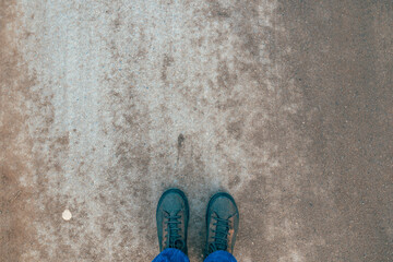 POV feet in boots standing at concrete asphalt