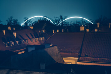 Illuminated Zezelj Bridge arches over rooftops in Petrovaradin, Novi Sad at night