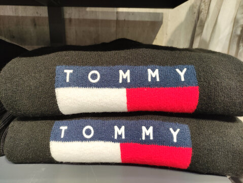 Rome, Italy - January 09, 2026: Tommy Hilfiger branded sweaters stacked neatly on display, showcasing the iconic logo and vibrant colors, perfect for fashion enthusiasts and casual wear lovers
