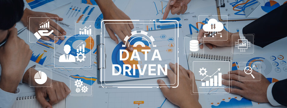 A group of professionals collaborate in a modern office, focusing on data-driven strategies using charts and digital tools to enhance business performance and growth. Trope - Powered by Adobe