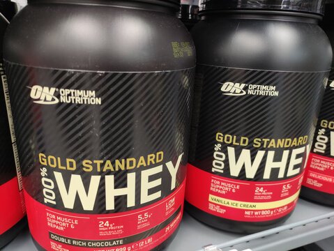 Rome, Italy - January 08, 2026: Optimum Nutrition Gold Standard 100% Whey protein powder containers displayed on a store shelf, showcasing popular flavors and branding for fitness enthusiasts