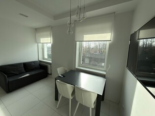 Modern bright dining area with sofa and large windows